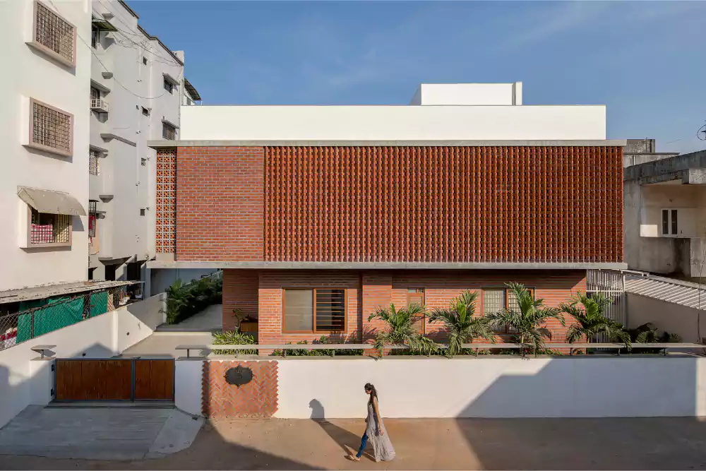 Brick screen house with Moroccan tile flooring and central open space.